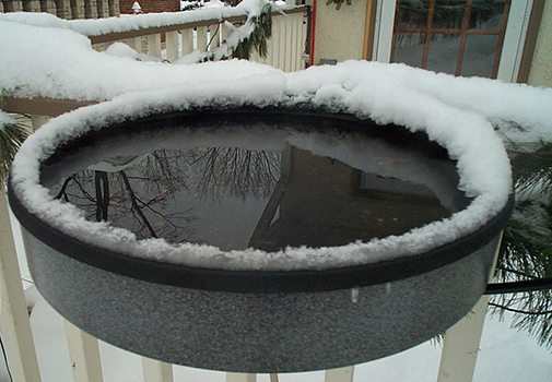 The Backyard Naturalist stocks and recommends Erva's Heated Bird Bath - Clamped to deck railing in winter snow and ice